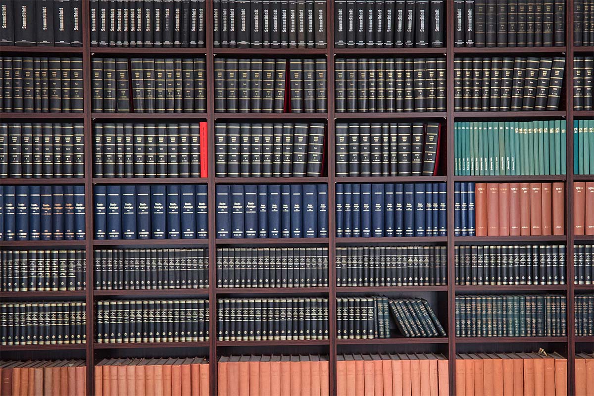 Gro&szlig;es B&uuml;cherregal mit zahlreichen gebundenen Fachb&uuml;chern und Gesetzessammlungen in verschiedenen Farben.